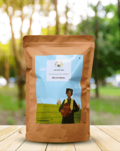 The Deep Soil Millet Pasta package on wooden table with sunlit trees background