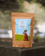 The Deep Soil Foxtail Millet Flour Kangni Atta brown paper package on a stone surface with nature background